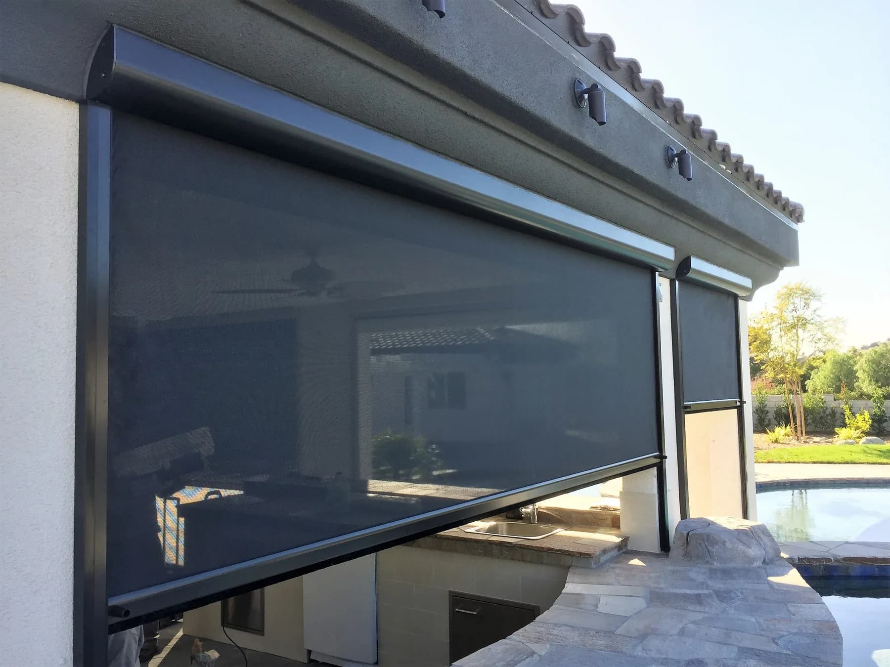 Poolside outdoor room with a motorized screen system